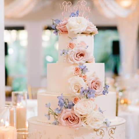 Wedding Ideas: A four tier wedding cake adorned with natural roses and a topper